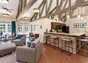Thumbnail 4 of 29 - A living room with a bar and a kitchen area.