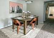 Thumbnail 22 of 29 - A dining room with a table set for two and a painting of a desert scene on the wall.