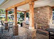 Thumbnail 14 of 29 - A patio with a fireplace and chairs.