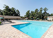Thumbnail 11 of 29 - A large swimming pool surrounded by trees and a building.