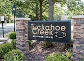 Thumbnail 18 of 29 - A sign for Tuckahoe Creek Apartment Homes is displayed in front of a landscaped area.