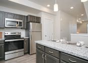Thumbnail 6 of 21 - Modern kitchen with granite countertops at Liberty Point Apartments, Utah