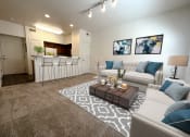 Thumbnail 9 of 15 - Liberty Landing Apartments Heathrow Floor Plan Living Room with couches, barstools and coffee table. West Jordan, Utah.