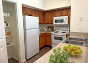 Thumbnail 11 of 15 - Liberty Landing Apartments Heathrow Floor Plan Kitchen with pantry, refrigerator, stove and sink. West Jordan, Utah.