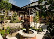 Thumbnail 17 of 22 - Liberty Gateway Apartments, Salt Lake City, Utah, a courtyard with a fountain and bench in front of a building.