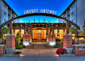 Thumbnail 20 of 22 - Liberty Gateway Apartments, Salt Lake City, UT, The entrance to the Liberty Gateway building is shown at dusk.