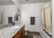 Thumbnail 11 of 34 - Bathroom with tub shower combo and granite counter at Liberty Gateway Apartments, Salt Lake City, UT 84101