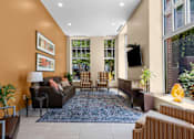 Thumbnail 23 of 34 - Community lounge with television and upholstered chairs at Liberty Gateway Apartments, Utah, 84101