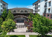 Thumbnail 31 of 34 - Courtyard entrance with pergola and surrounding buildings at Liberty Gateway Apartments, Salt Lake City, Utah