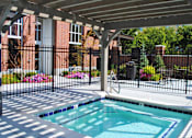 Thumbnail 16 of 22 - Liberty Gateway Apartments, Salt Lake City, Utah, a hot tub spa under a roof with a black fence around it.