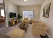 Thumbnail 13 of 15 - Liberty Landing Apartments in West Jordan Utah living room in Midway floor plan with couch, coffee table and television.
