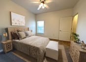 Thumbnail 12 of 15 - Liberty Landing Apartments in West Jordan Utah bedroom with a full-sized bed and ceiling fan.