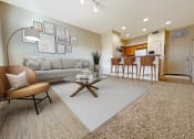 Thumbnail 6 of 18 - Liberty Bend Apartments, Sandy, Utah, living room with a couch and a table in front of a kitchen