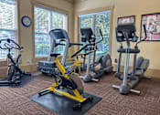 Thumbnail 20 of 20 - Liberty Landing Apartments, West Jordan, UT, A gym with a variety of equipment including treadmills, stationary bikes, and elliptical machines.