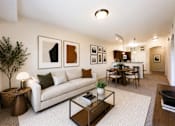 Thumbnail 17 of 20 - Liberty Landing Apartments, West Jordan, UT, A living room with a white couch, a coffee table, and a dining table with chairs.