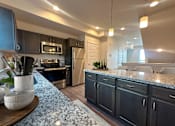 Thumbnail 15 of 21 - Open kitchen with stainless steel appliances at Liberty Point Apartments, Utah, 84020