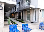 Thumbnail 18 of 18 - Two blue benches are in front of a building with the numbers 6 and 7 on it. at Liberty Square Apartments - Saltlake City, UT Apartments, Saltlake City, Utah
