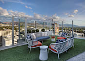 Thumbnail 31 of 41 - A rooftop patio with a couch, chairs, and a table.