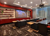 Thumbnail 15 of 41 - A conference room with a large screen and comfortable seating.