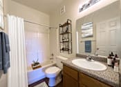 Thumbnail 7 of 23 - A bathroom with a white toilet and a white sink.