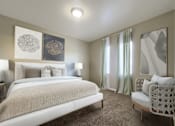 Thumbnail 5 of 23 - A bedroom with a large bed and a chair.