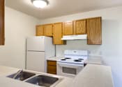 Thumbnail 8 of 23 - A kitchen with a white refrigerator, white stove, and white oven.