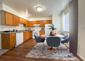 Thumbnail 3 of 23 - The Ridge at Jordan Landing Apartments, West Jordan, Utah, kitchen and dining area with a round table and chairs, dishwasher, ample counter space.