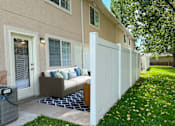 Thumbnail 4 of 23 - The Ridge at Jordan Landing Apartments, West Jordan, Utah, a patio with an outdoor couch in front of an apartment/townhome.