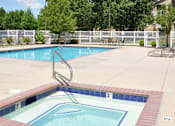 Thumbnail 16 of 23 - A pool with a diving board and a tree in the background.