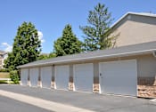 Thumbnail 21 of 23 - A row of white garage doors in front of a building.