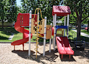 Thumbnail 19 of 23 - A playground with a red slide and a yellow and blue structure.