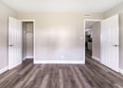 Thumbnail 9 of 19 - an empty room with wooden floors and white doors at Palm Cove Apartments, Florida, 32114