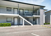 Thumbnail 13 of 19 - an exterior view of a building with stairs and a parking lot at Palm Cove Apartments, Daytona Beach Florida