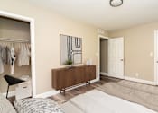 Thumbnail 10 of 19 - A room with a white bed and a brown dresser.