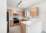 Thumbnail 8 of 29 - a kitchen with white countertops and wooden cabinets