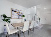 Thumbnail 2 of 29 - a dining room with a wooden table and white chairs