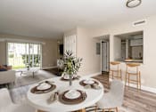 Thumbnail 1 of 19 - A dining room with a white table set for six.