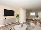 Thumbnail 2 of 19 - A living room with a white coffee table and a grey cabinet.