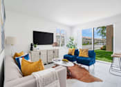 Thumbnail 1 of 29 - a living room with white tile flooring and a sliding glass door that leads to a yard