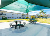 Thumbnail 17 of 19 - A green canopy over a picnic table in a sunny outdoor setting.