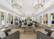 Thumbnail 17 of 29 - a living room with couches and chairs and chandeliers