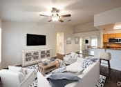 Thumbnail 6 of 14 - a living room with a white couch and a ceiling fan