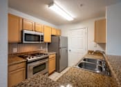 Thumbnail 7 of 14 - Kitchen with microwave, stove and refrigerator