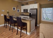 Thumbnail 19 of 24 - A kitchen with brown chairs and a white fridge.