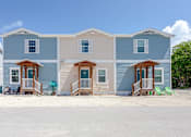 Thumbnail 13 of 22 - A row of three houses with blue siding and white trim.
