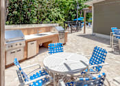 Thumbnail 18 of 22 - A patio with a table and chairs under a wooden pergola.