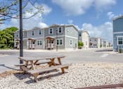 Thumbnail 14 of 22 - A row of houses with a picnic table in front.