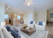 Thumbnail 1 of 24 - A living room with a white couch and a coffee table.