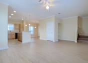 Thumbnail 6 of 24 - A spacious living room with a staircase leading to the upper floor.
