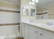 Thumbnail 15 of 24 - A bathroom with a white tub and sink.
